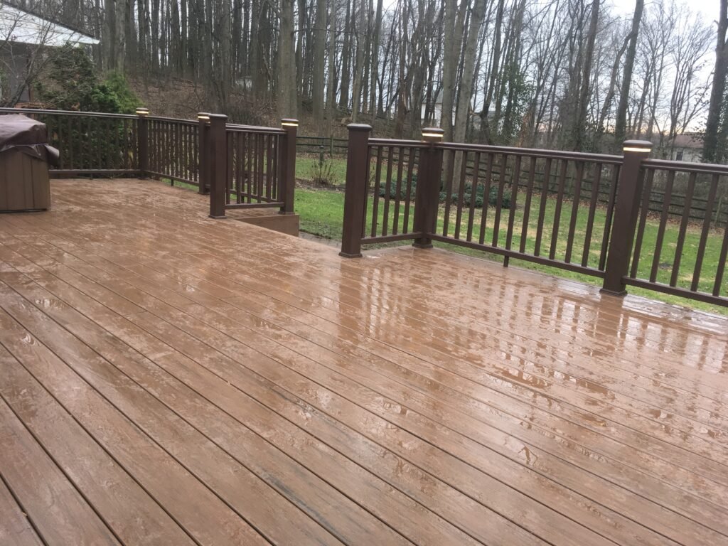 Master-certified deck builders installing a custom multi-level outdoor living space with hidden fastener systems and Dark Sky-compliant LED perimeter lighting.